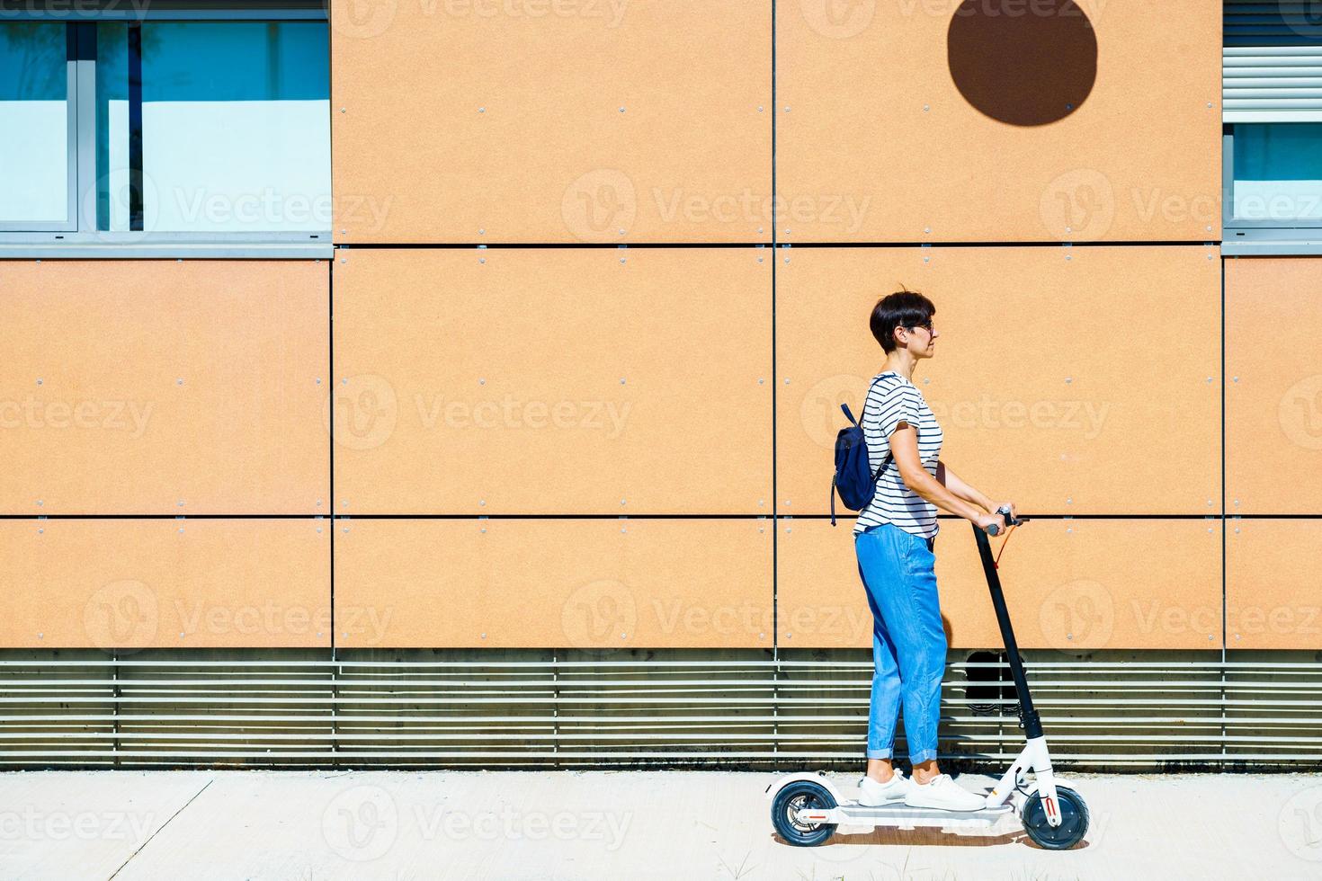 Woman riding around town on an electric scooter photo