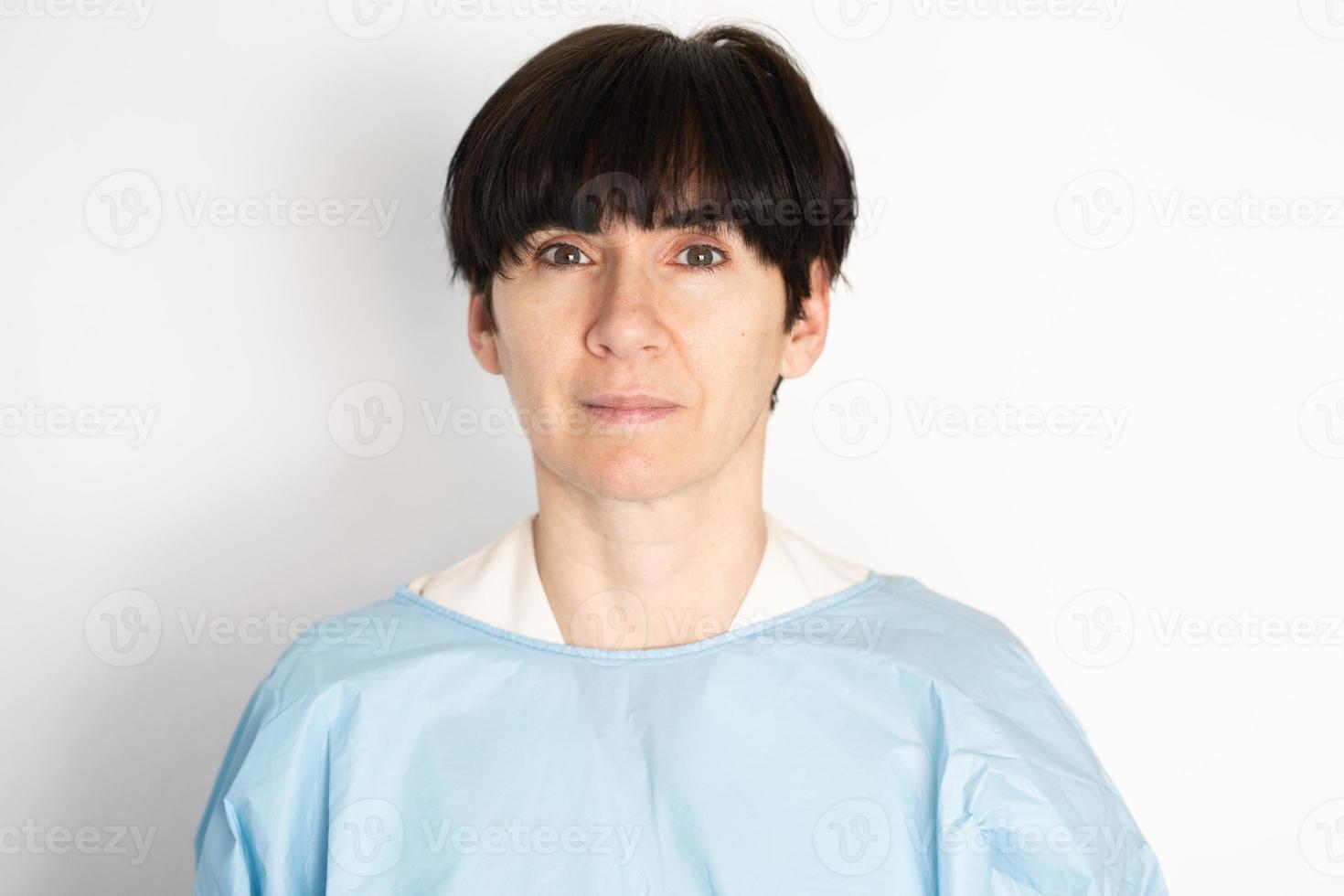 Middle-aged doctor putting on a protective gown photo