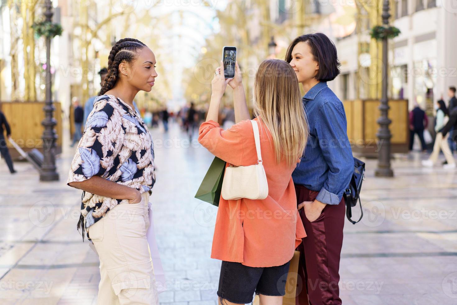 diversas mujeres tomando selfie en smartphone en la calle foto