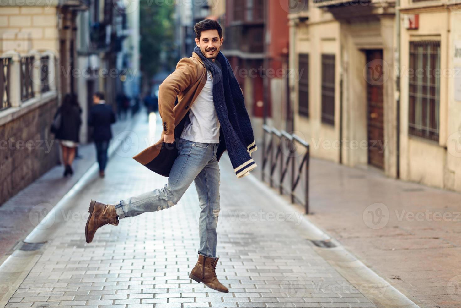 Noche africano Objeción joven hombre feliz saltando con ropa de invierno en el fondo urbano 6520060  Foto de stock en Vecteezy