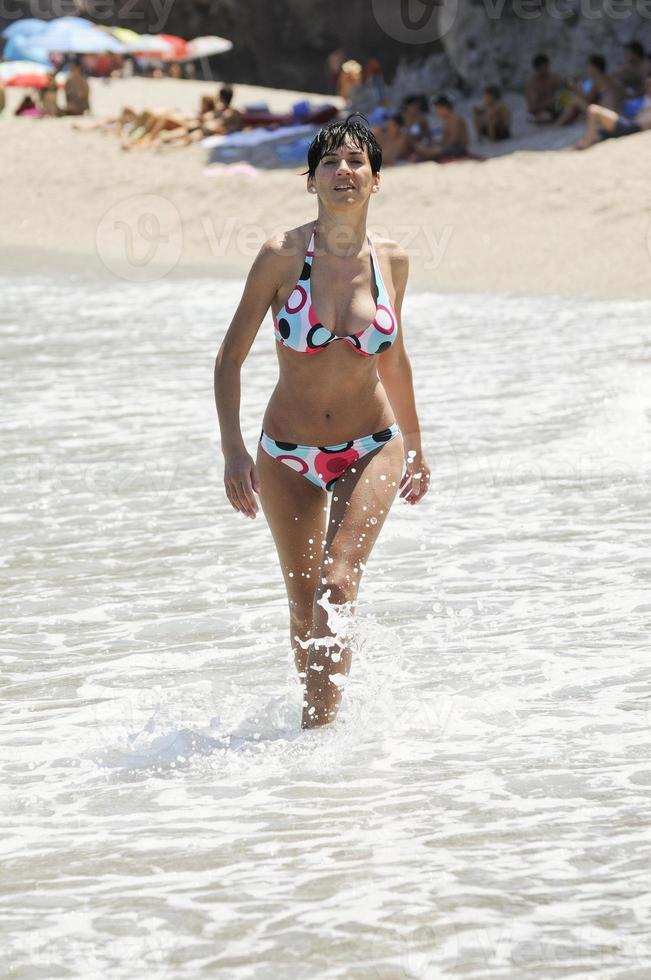 Woman with beautiful body in swimwear smiling in a tropical beach. photo