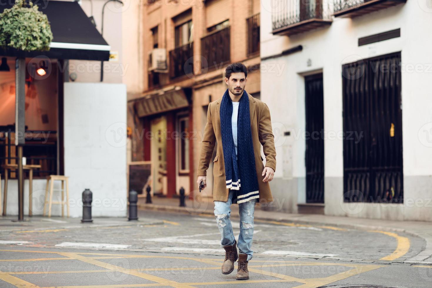 Young man wearing winter clothes with a smartphone in his hand photo