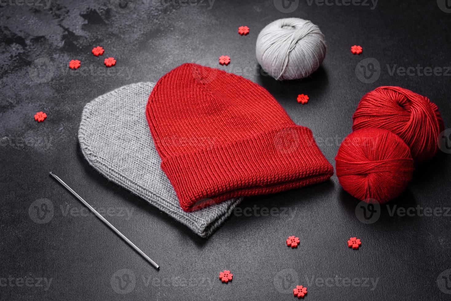 Red warm knitted women's hat on a concrete background photo