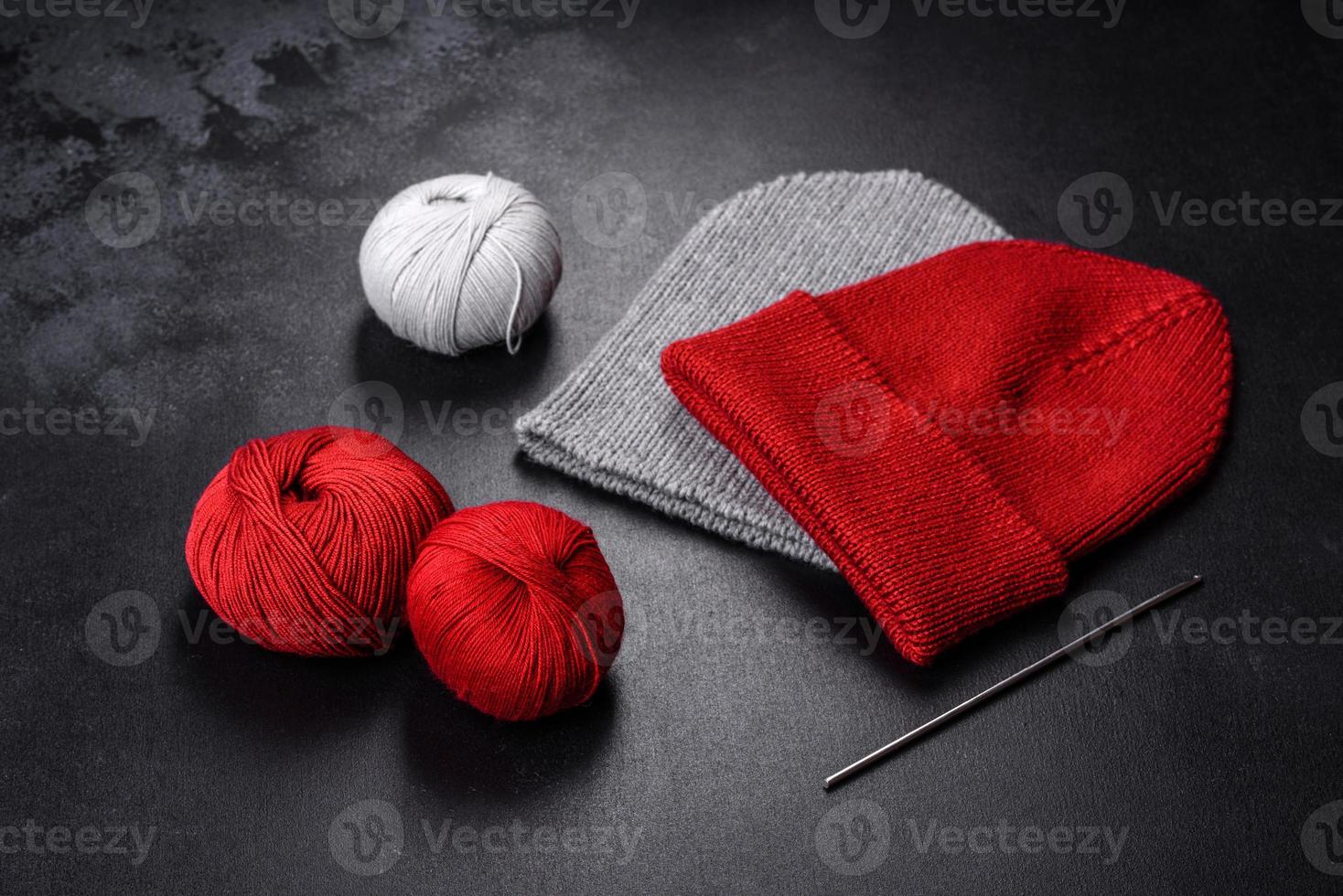 Red warm knitted women's hat on a concrete background photo