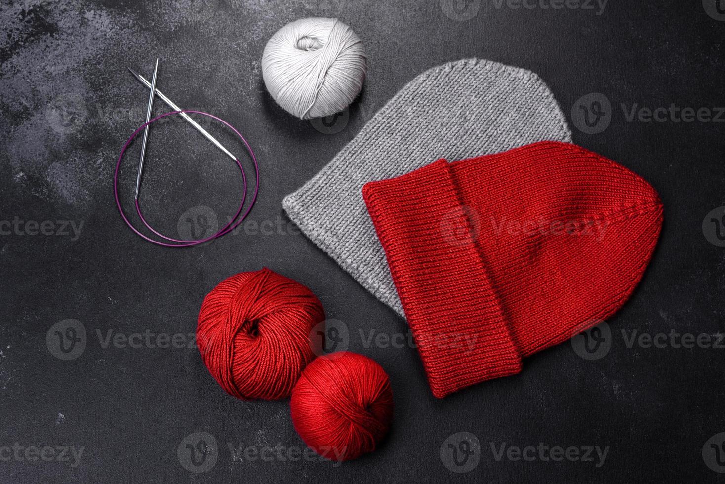 Red warm knitted women's hat on a concrete background photo