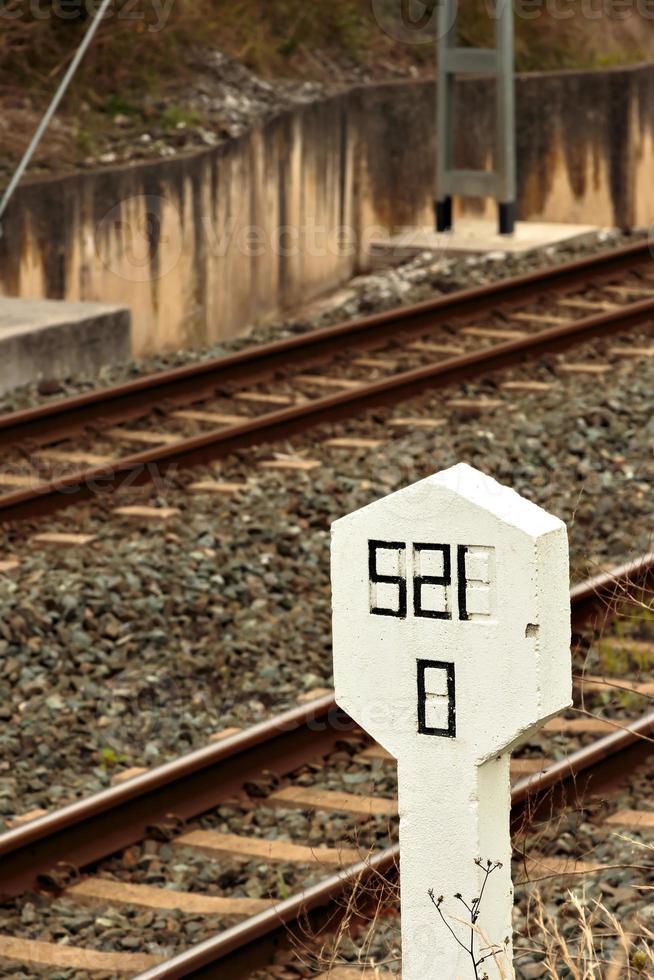 señal de piedra en la vía férrea. imagen vertical foto