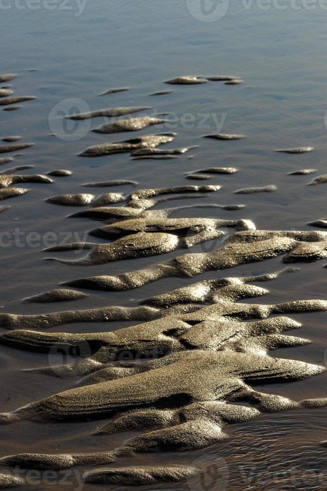 Sand after low tide on a beach in Cantabria, Spain. Vertical image. photo