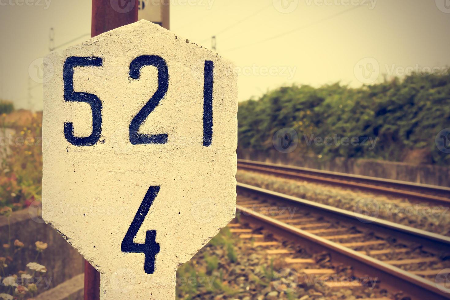 señal de piedra en la vía férrea. estilo retro de la vendimia. imagen horizontal foto