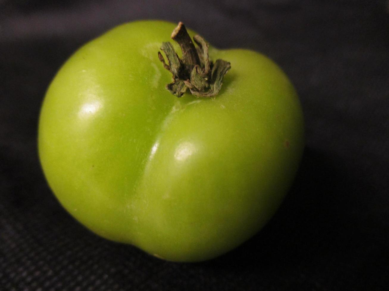 green tomatoes on a black background photo