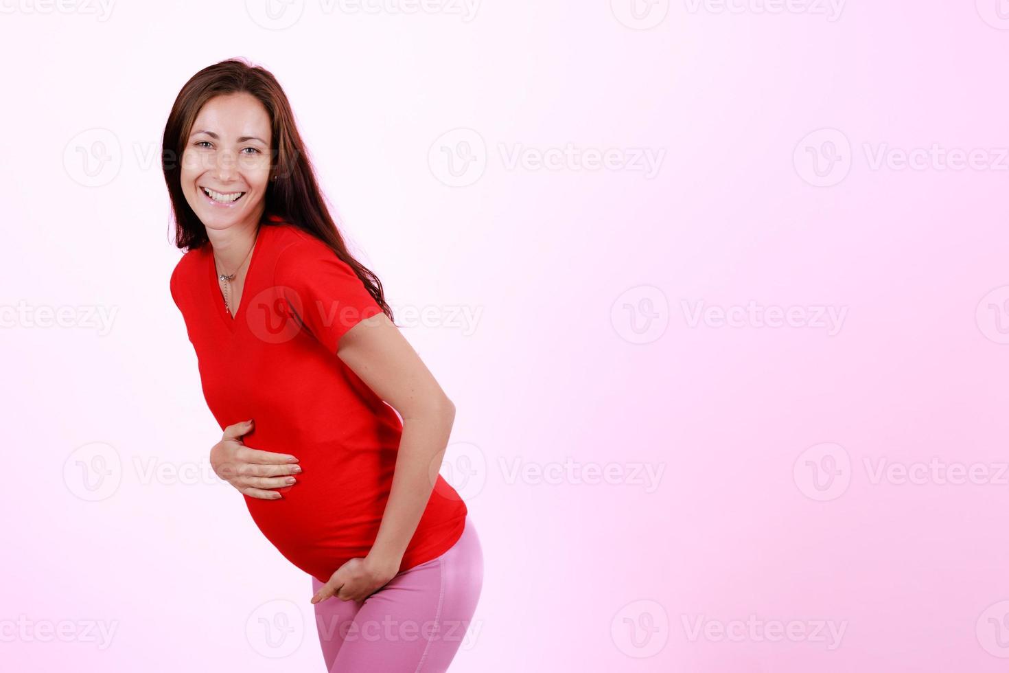 Half length portrait of beautiful caucasian young pregnant model caressing tender touch her belly. Pregnant happy new mother posing indoor put hand soft touching on tummy. Love and family concept photo