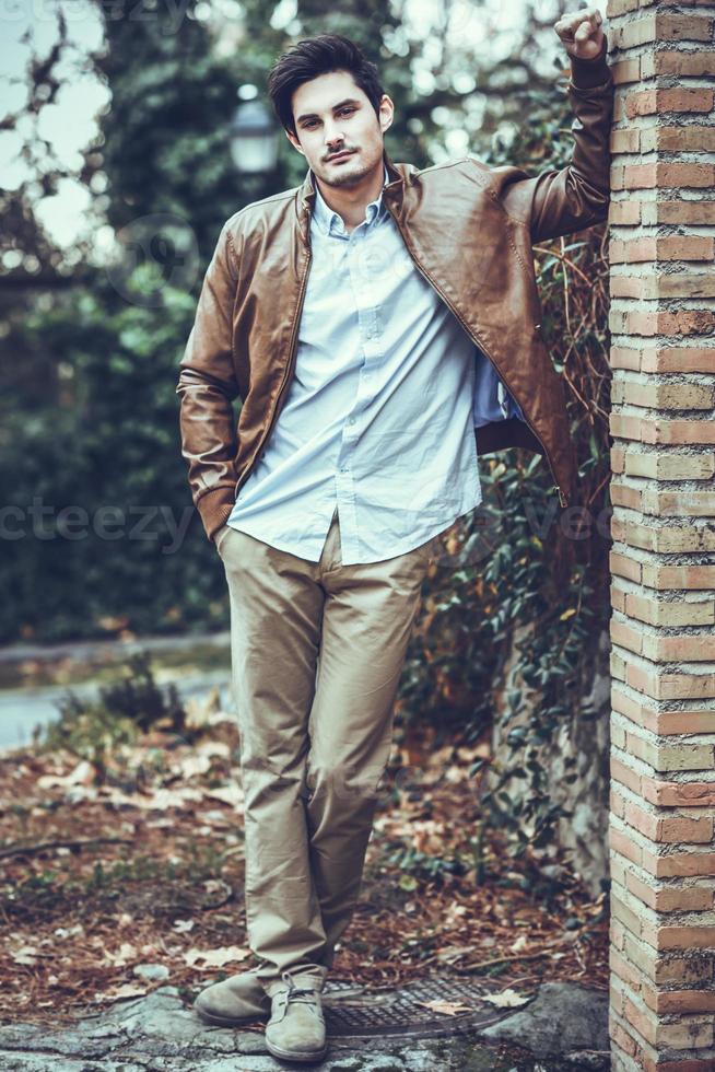 Attractive young handsome man, model of fashion in urban background photo