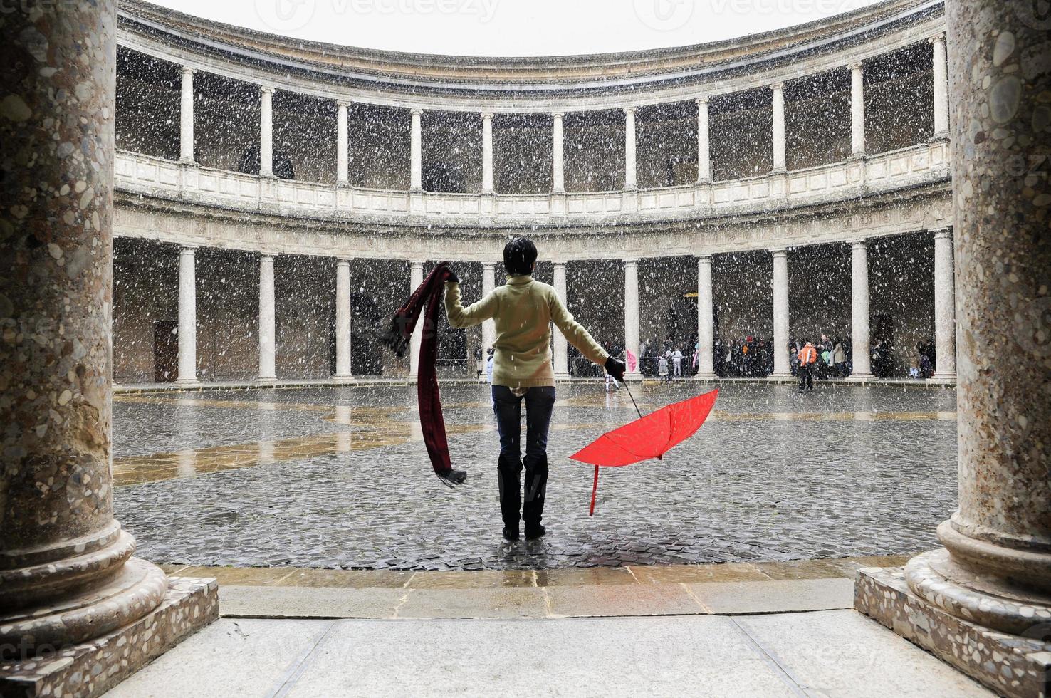 Snowing over woman with red umbrella in palace photo