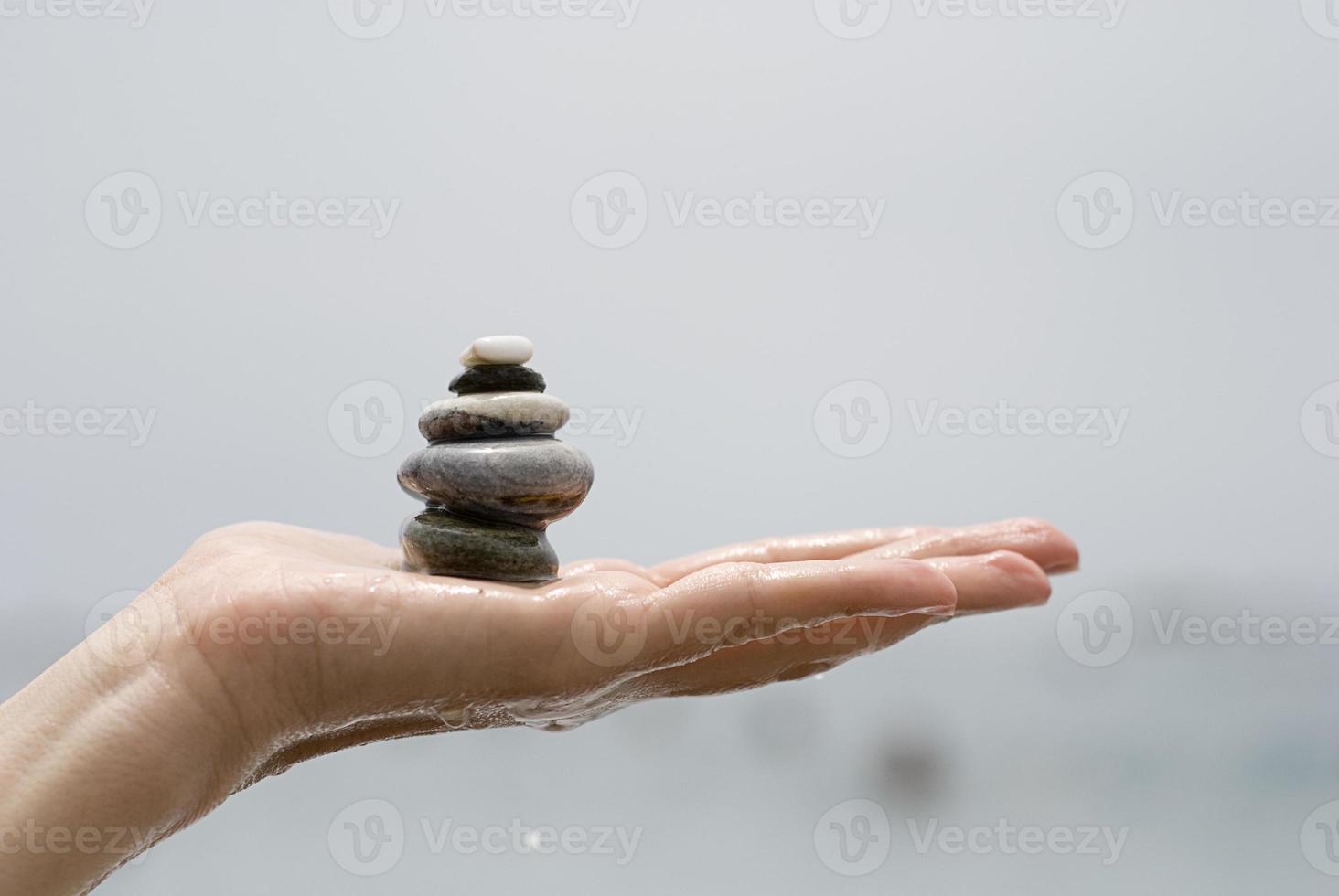 Gravel pile in woman's hands with sea background photo