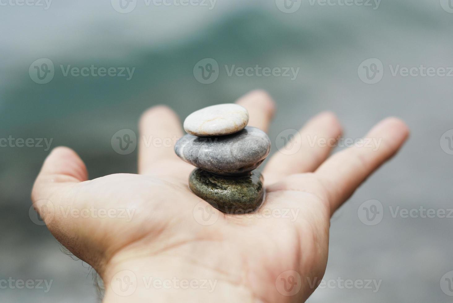 Gravel pile in woman's hands with sea background photo
