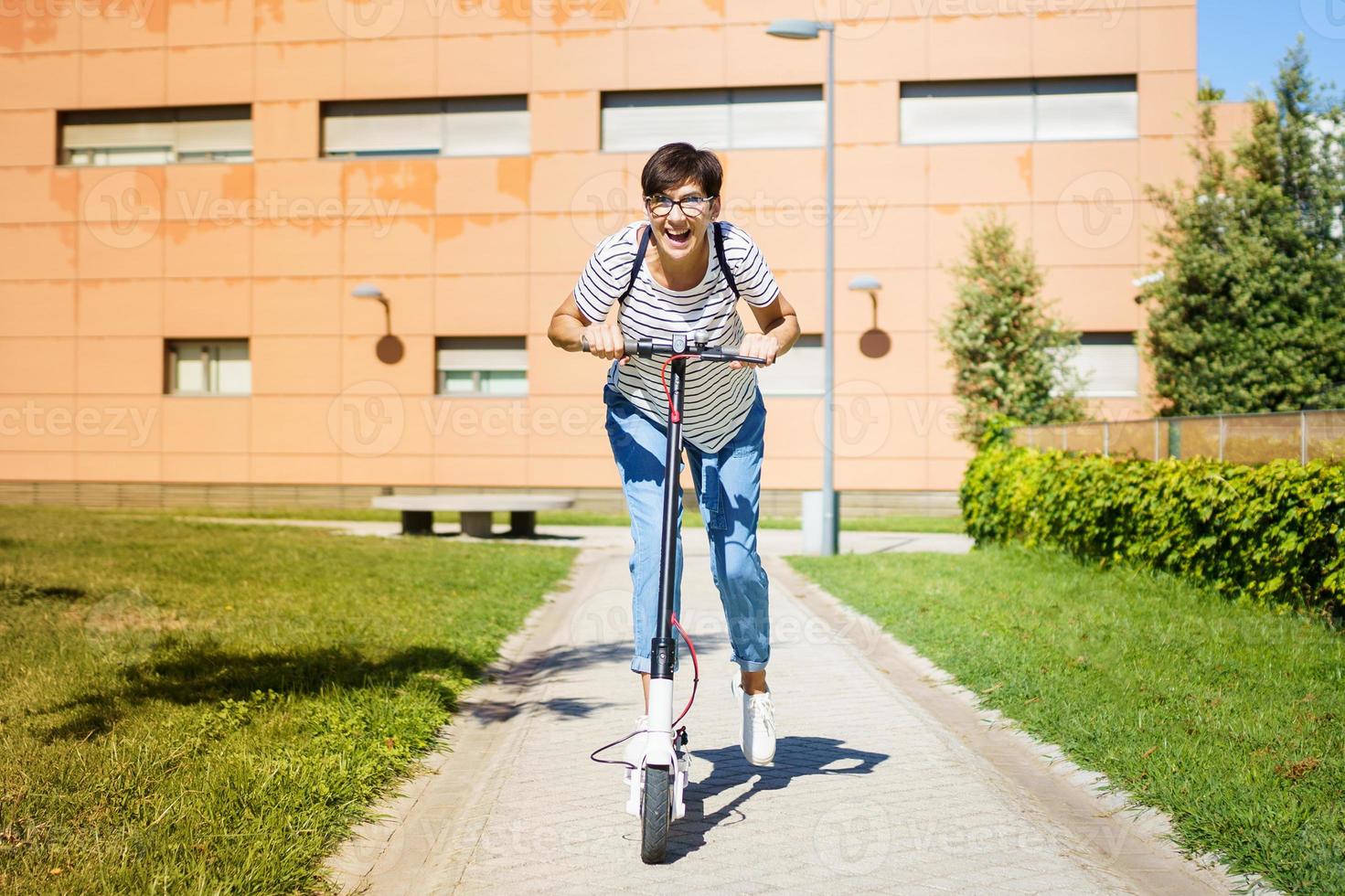 Woman riding around town on an electric scooter photo