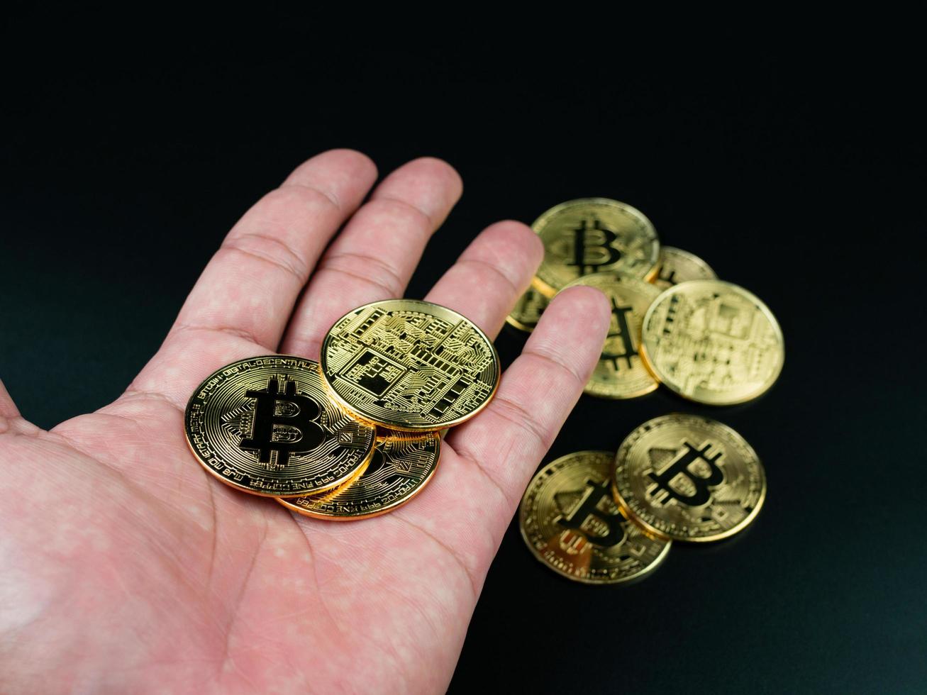 moneda bitcoin colocada en la mano sobre un fondo negro foto