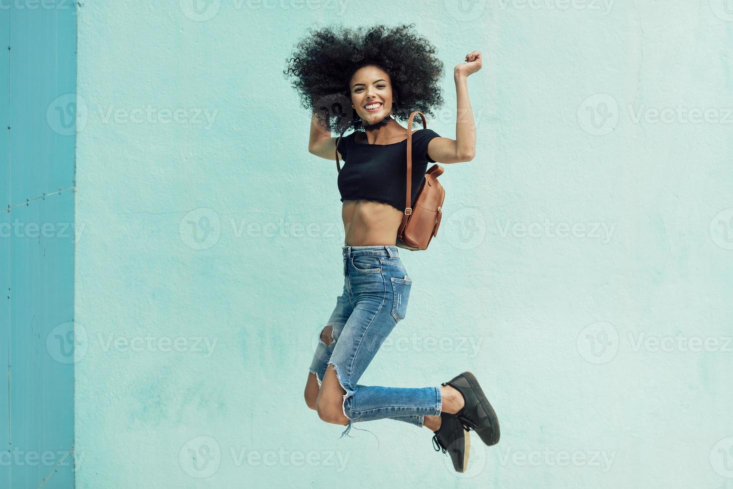 sonriente mujer mixta con pelo afro de pie en la calle 6519748 Foto de  stock en Vecteezy