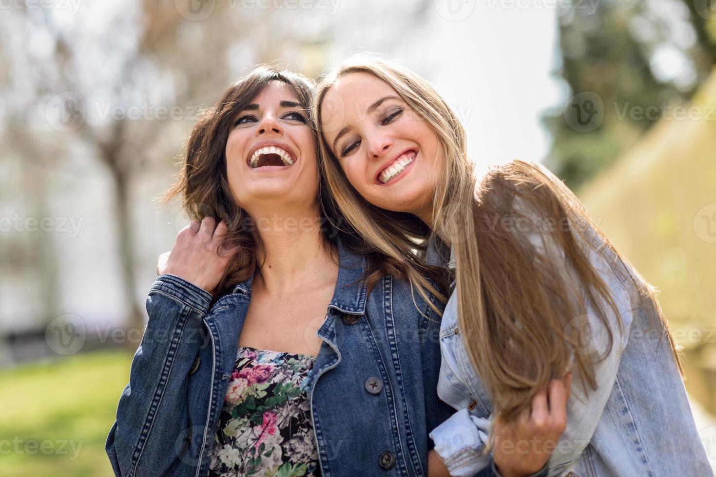 dos amigas jóvenes felices abrazándose en la calle. foto