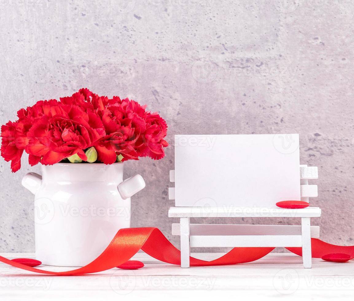 May mothers day handmade giftbox wishes photography - Beautiful blooming carnations with red ribbon box isolated on fair-faced gray background desk, close up, copy space, mock up photo