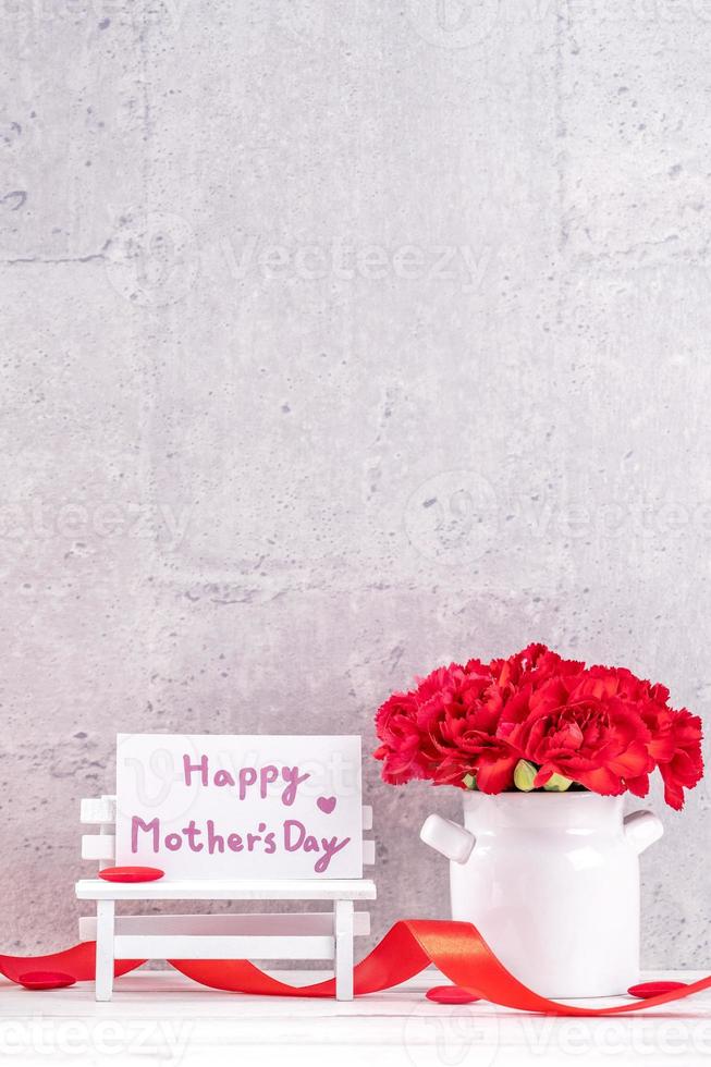 May mothers day handmade giftbox wishes photography - Beautiful blooming carnations with red ribbon box isolated on fair-faced gray background desk, close up, copy space, mock up photo