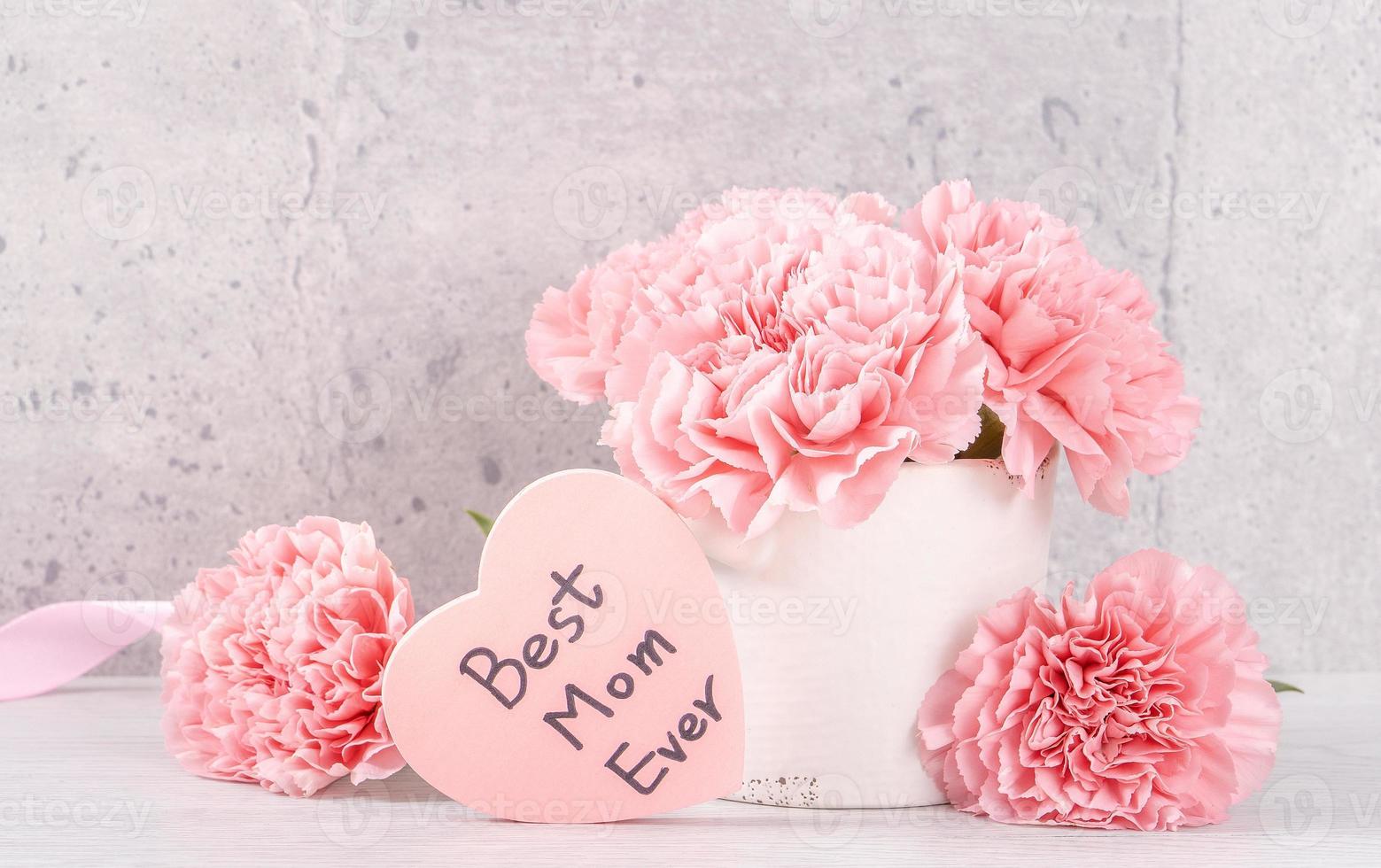 Mothers day handmade giftbox surprise wishes photography - Beautiful blooming carnations with pink ribbon box isolated on gray wallpaper design, close up, copy space photo