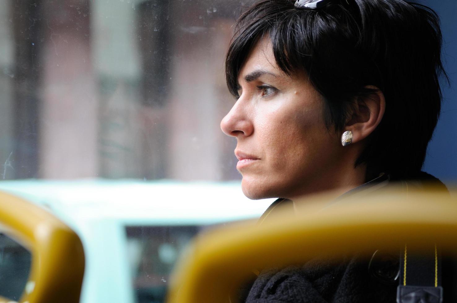 Woman looking through the glass of the bus photo