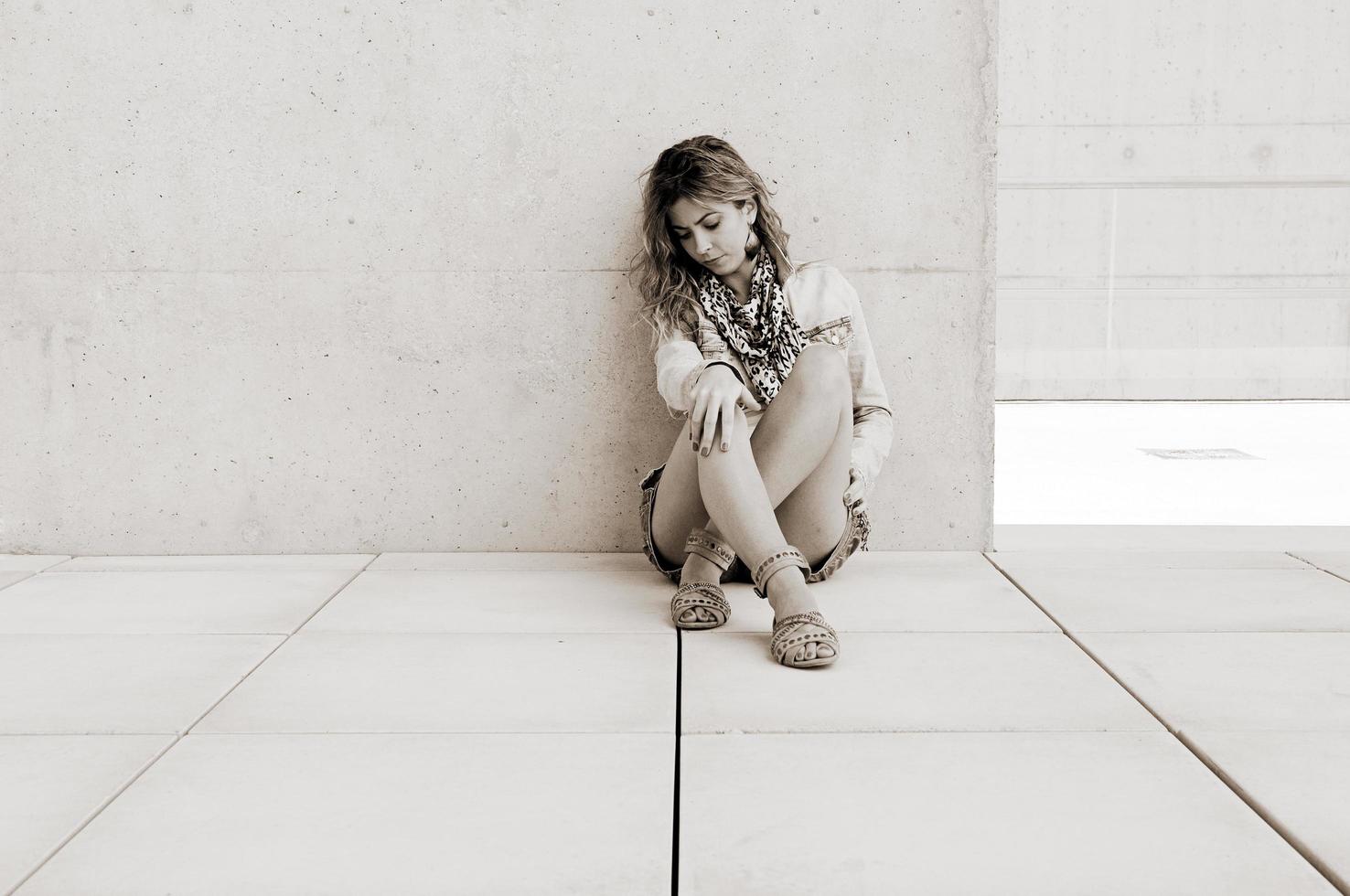 Young blonde woman against urban wall photo