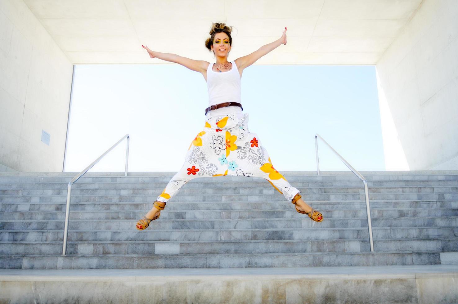 Happy young woman jumping in urban background. photo