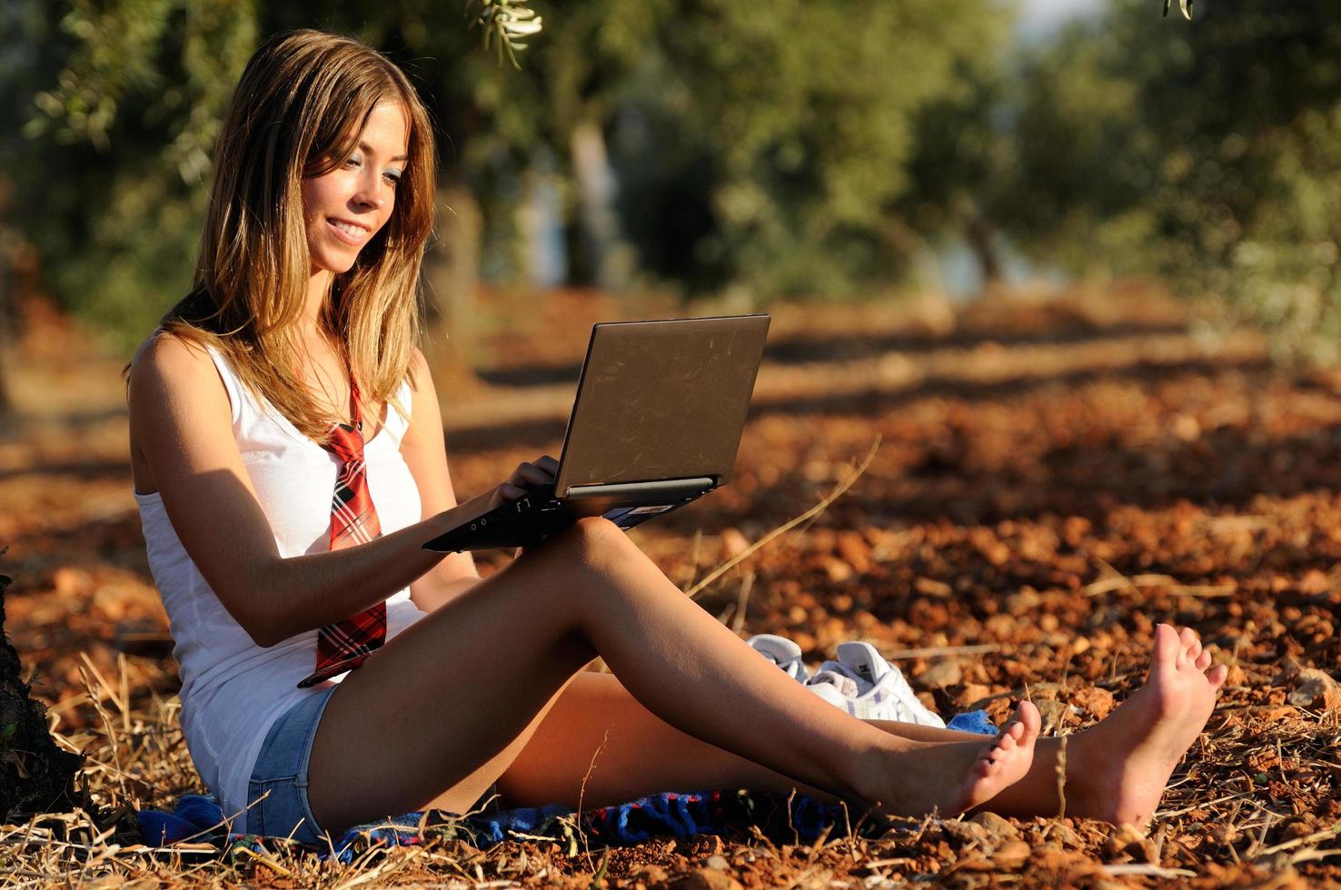Girl with a laptop in a field in autumn photo