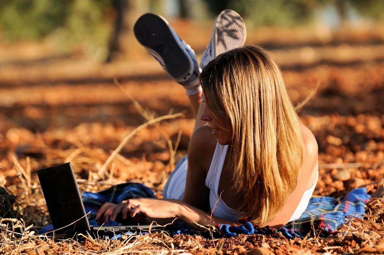 Girl with a laptop in a field in autumn photo