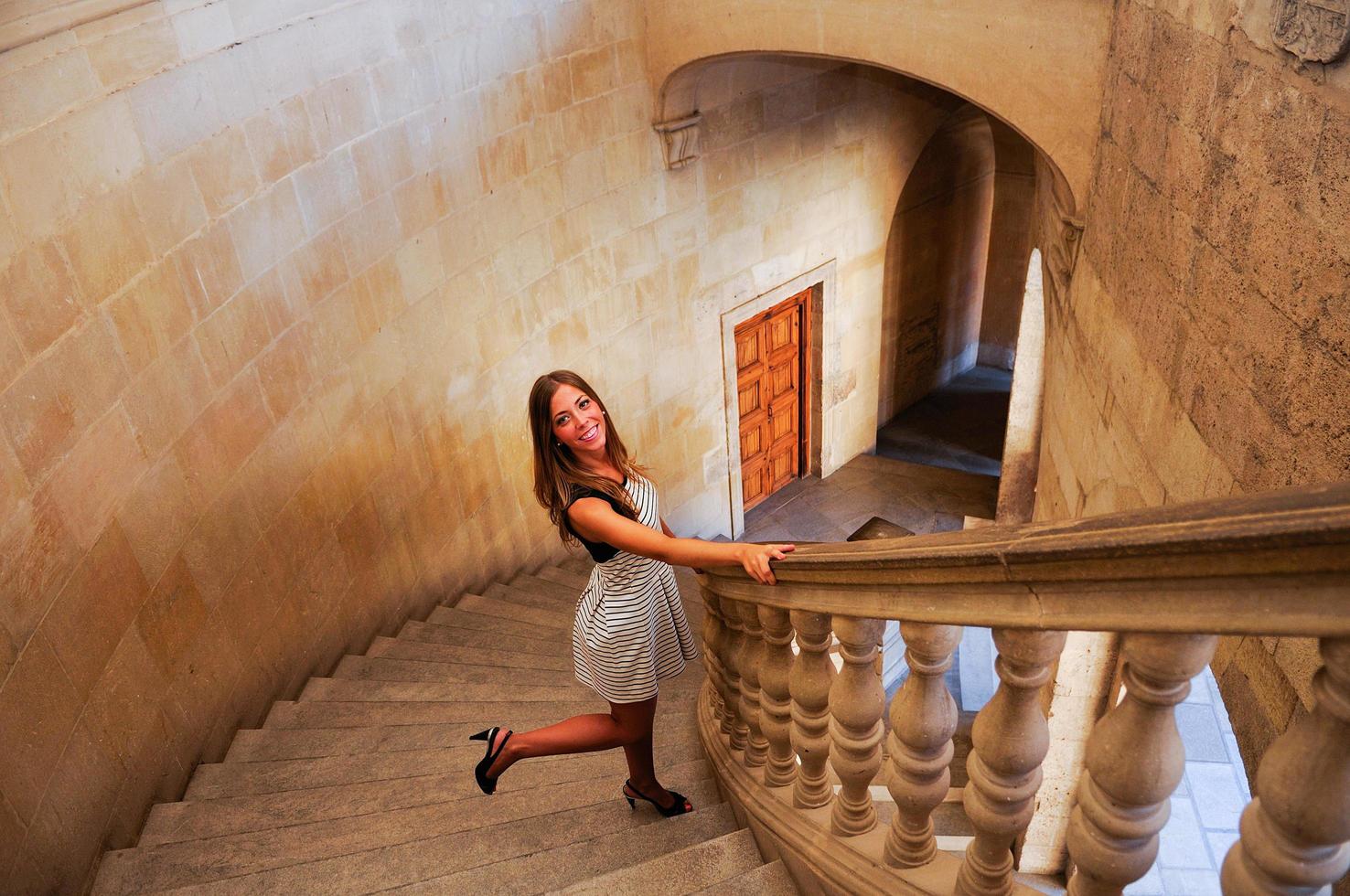 Attractive smiling blonde woman on beautiful stairs photo