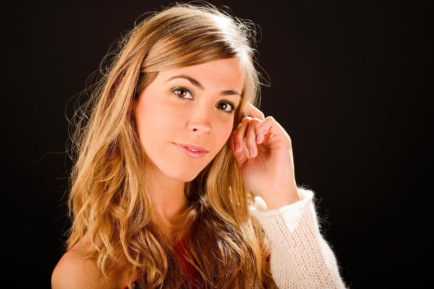 Young blonde woman studio portrait on black background photo