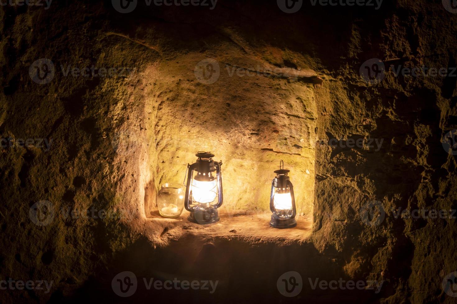 Kerosene lamp is burning at night on a pedestal in an old castle ruin photo