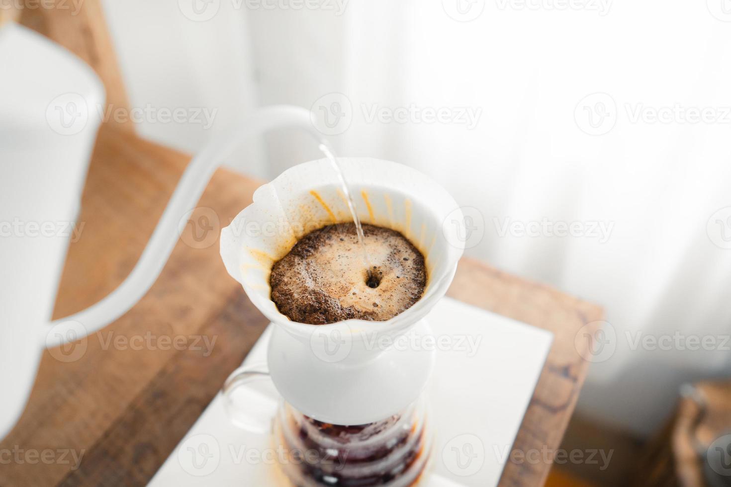 Drip coffee,Pouring a hot water over a drip coffee on the table photo