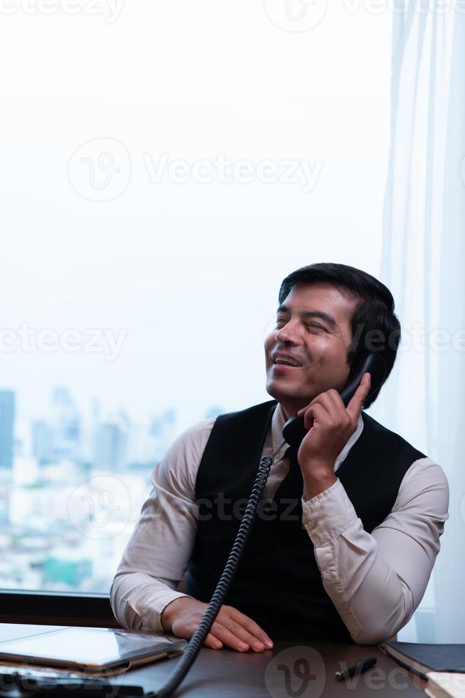 A young businessman monitors and keeps track of tasks in his office photo