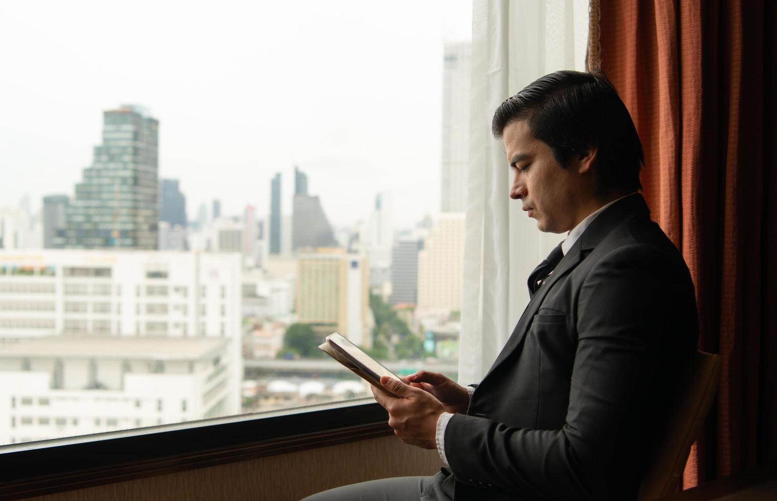 A young businessman monitors and keeps track of tasks in his office photo