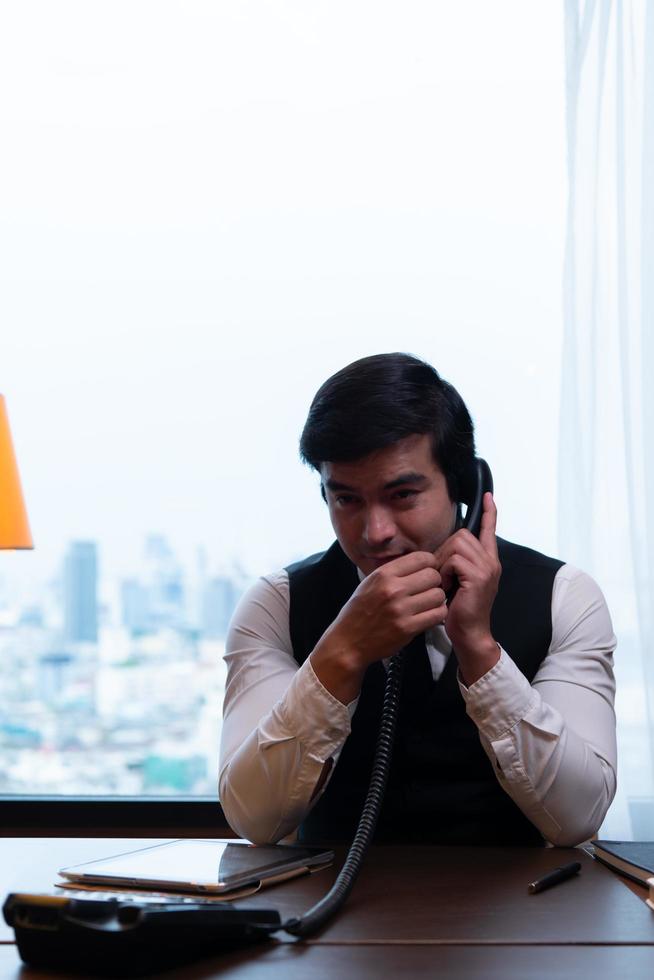 A young businessman monitors and keeps track of tasks in his office photo