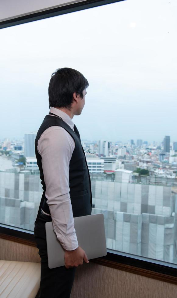 A young businessman monitors and keeps track of tasks in his office photo