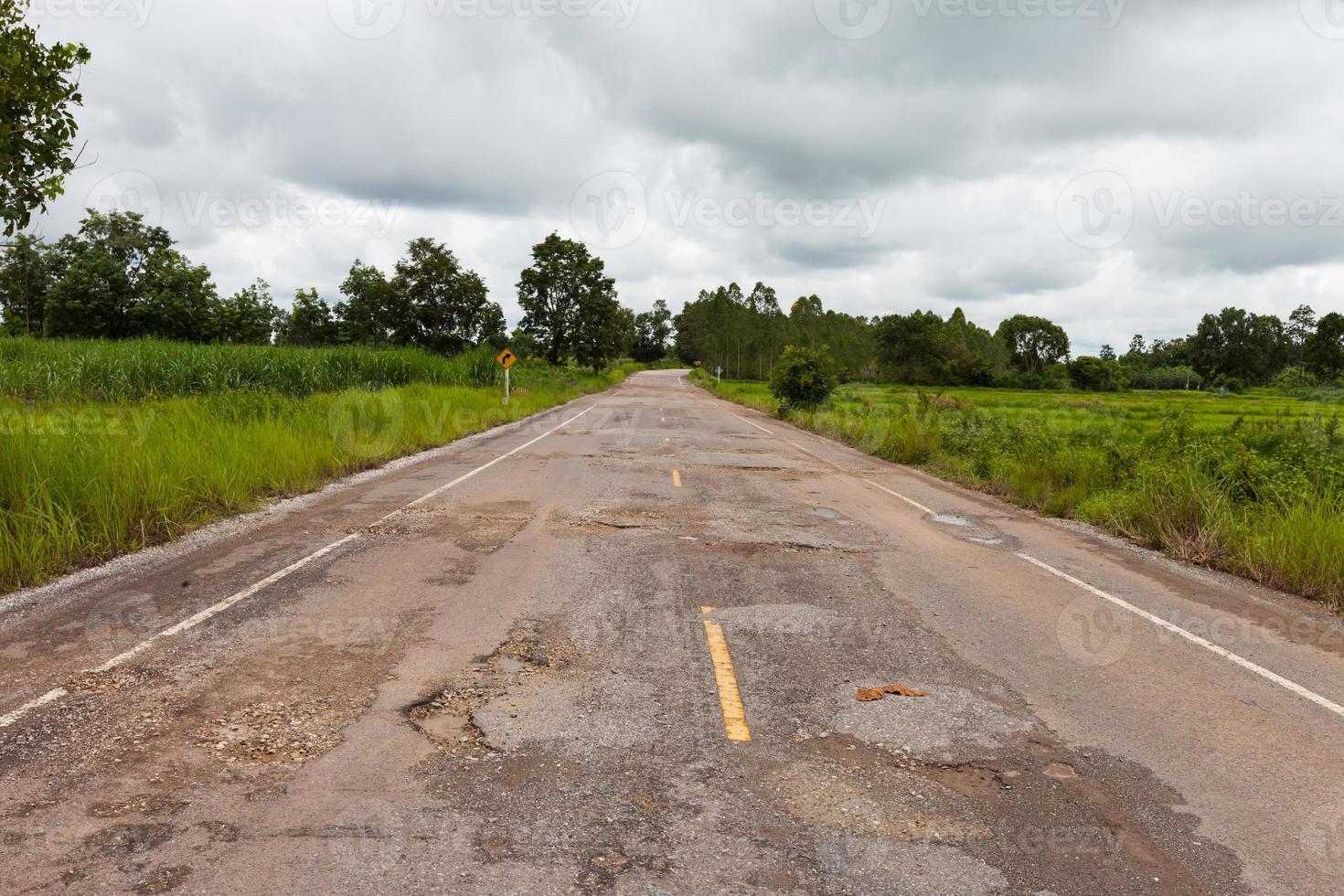 Damaged asphalt pavement road with potholes photo