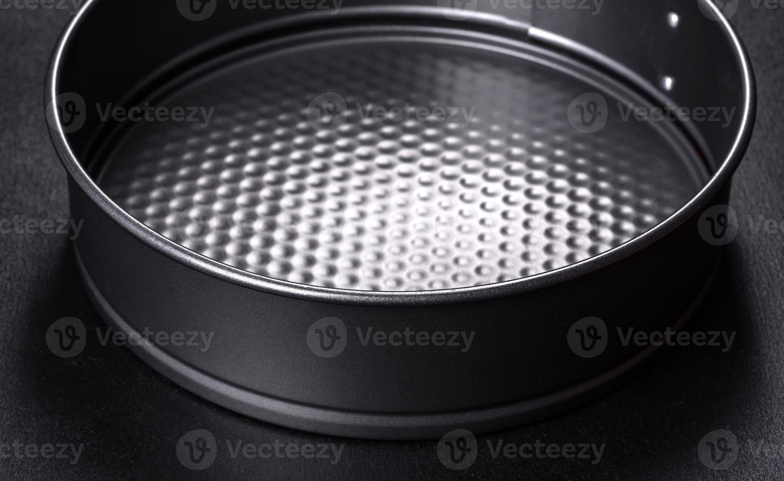 Round cake pan, tray or mould on a black concrete background photo