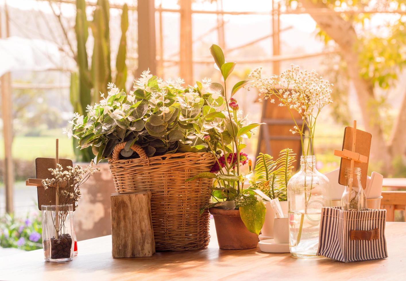 Table decorated with flower vases, Background with sunlight, Vintage style photo