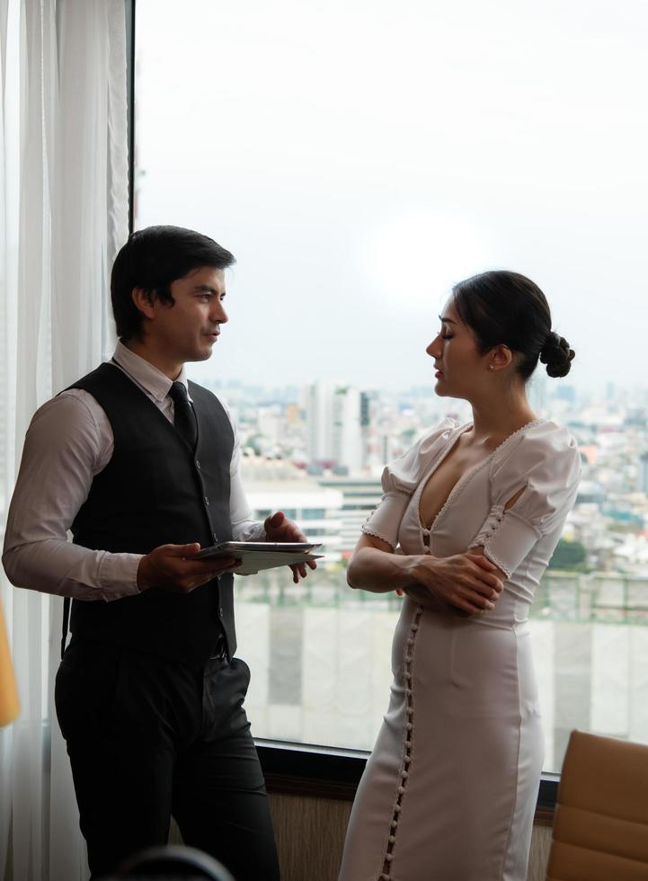 Businessmen consulting work that need to be carried out with assistants In an office with a cityscape in the background photo