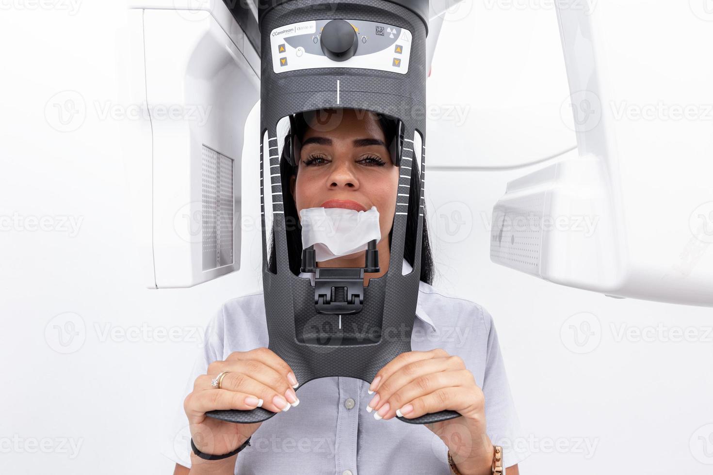 mujer con la cara en una máquina blanqueadora de dientes en una clínica dental foto