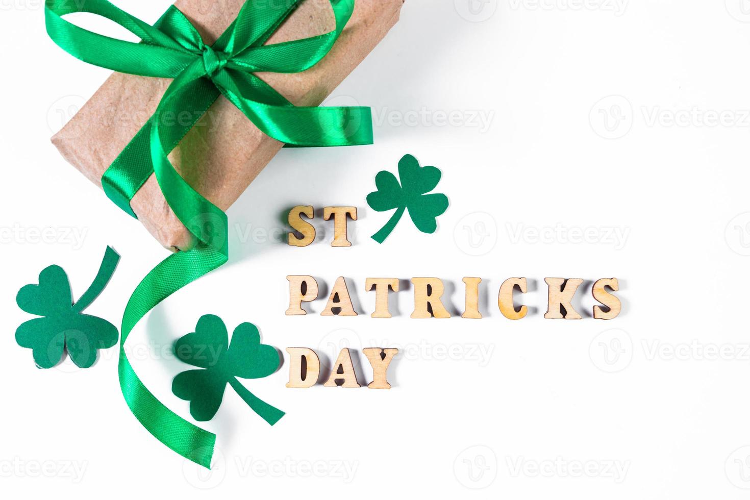 Shamrock and gift with green ribbon on a white background. Good luck symbols for St. Patrick's Day. photo