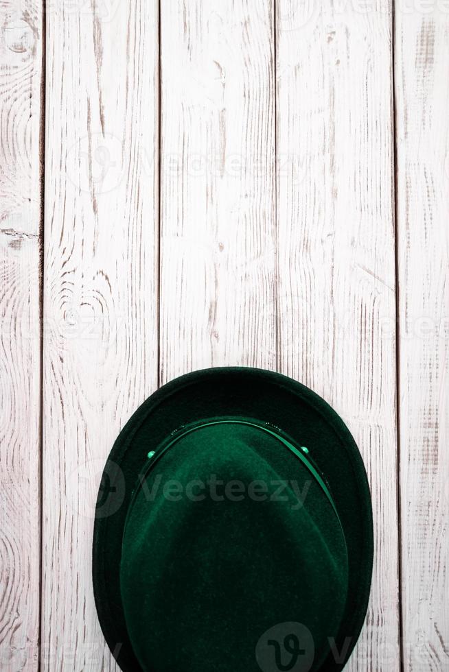 Happy St. Patrick's Day. Leprechaun hat and clover shamrock on a light wooden background. photo