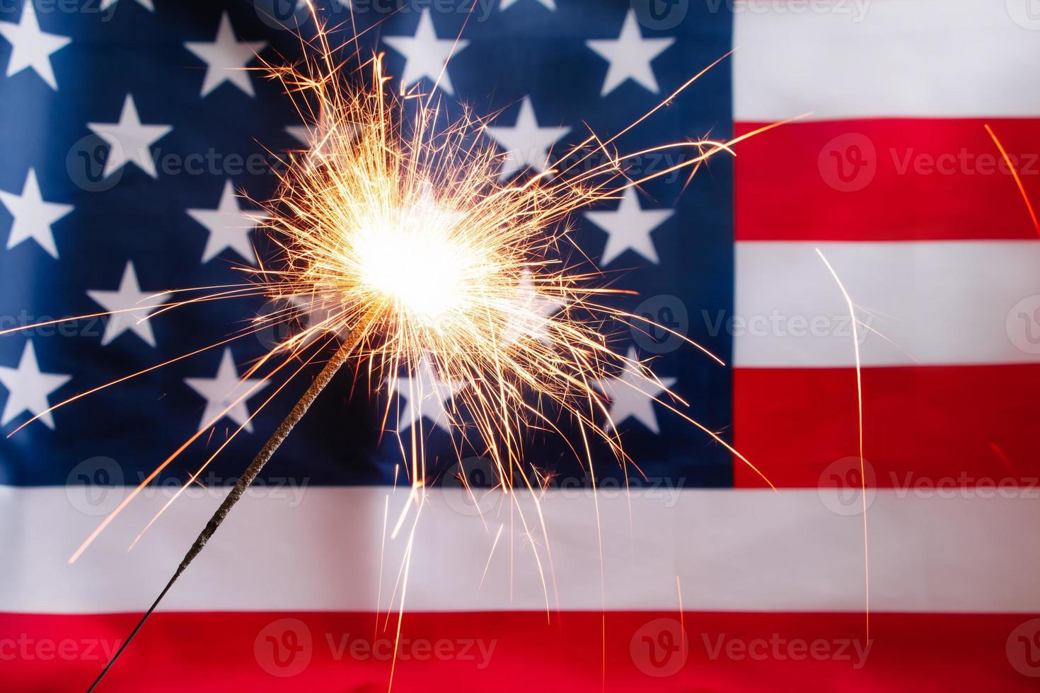 Concept for celebrating US Independence or Memorial Day. Sparkler on a background of American flag. photo