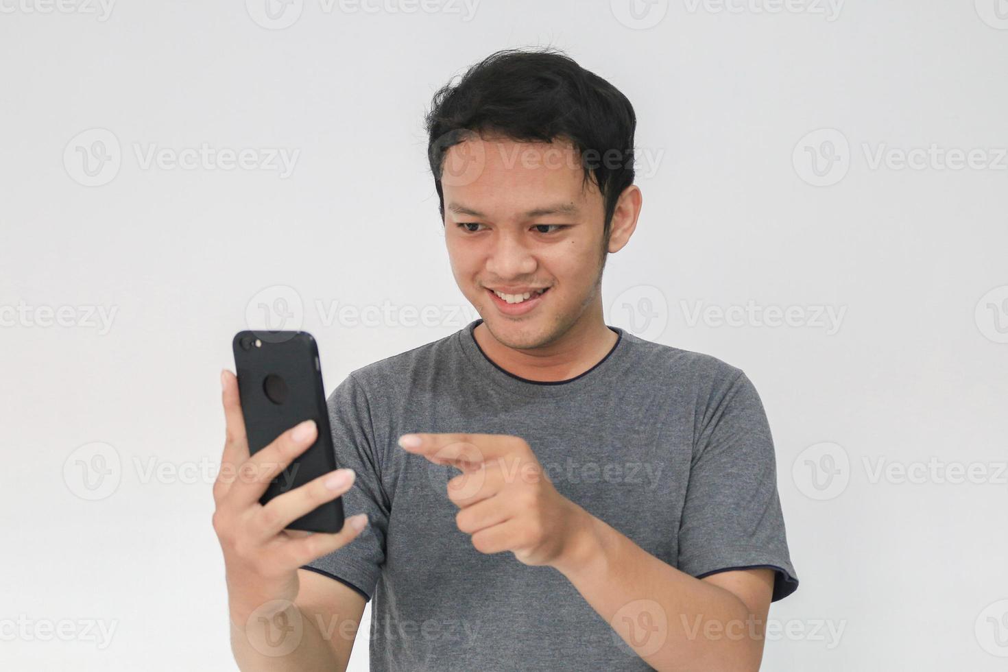 Wow face and feeling happy of Young Asian man in grey t-shirt get surprised on the smartphone. photo