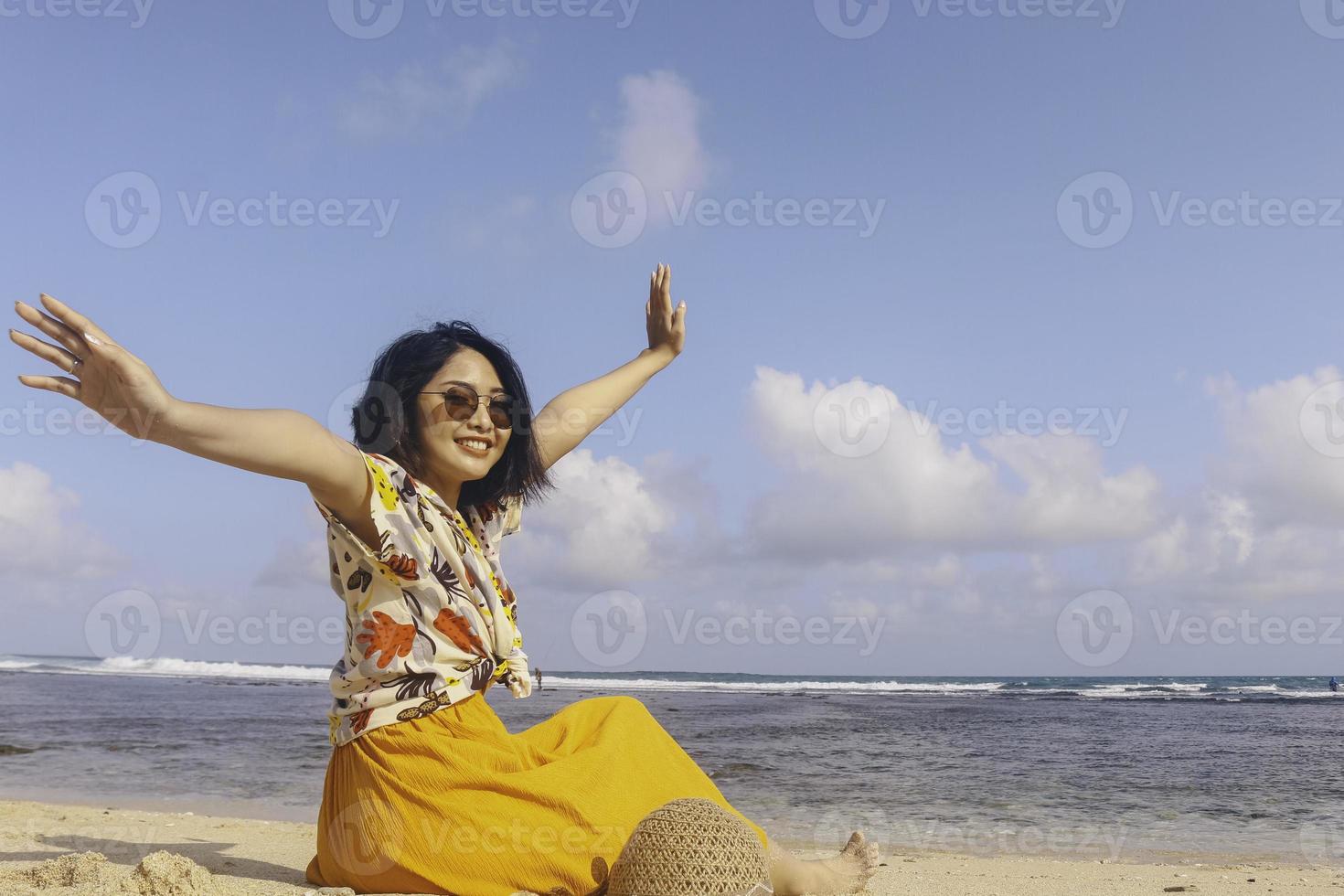 Portrait of happy smiling Asian woman on the beach wear hat photo