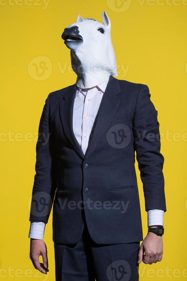 man with horse mask on yellow background photo