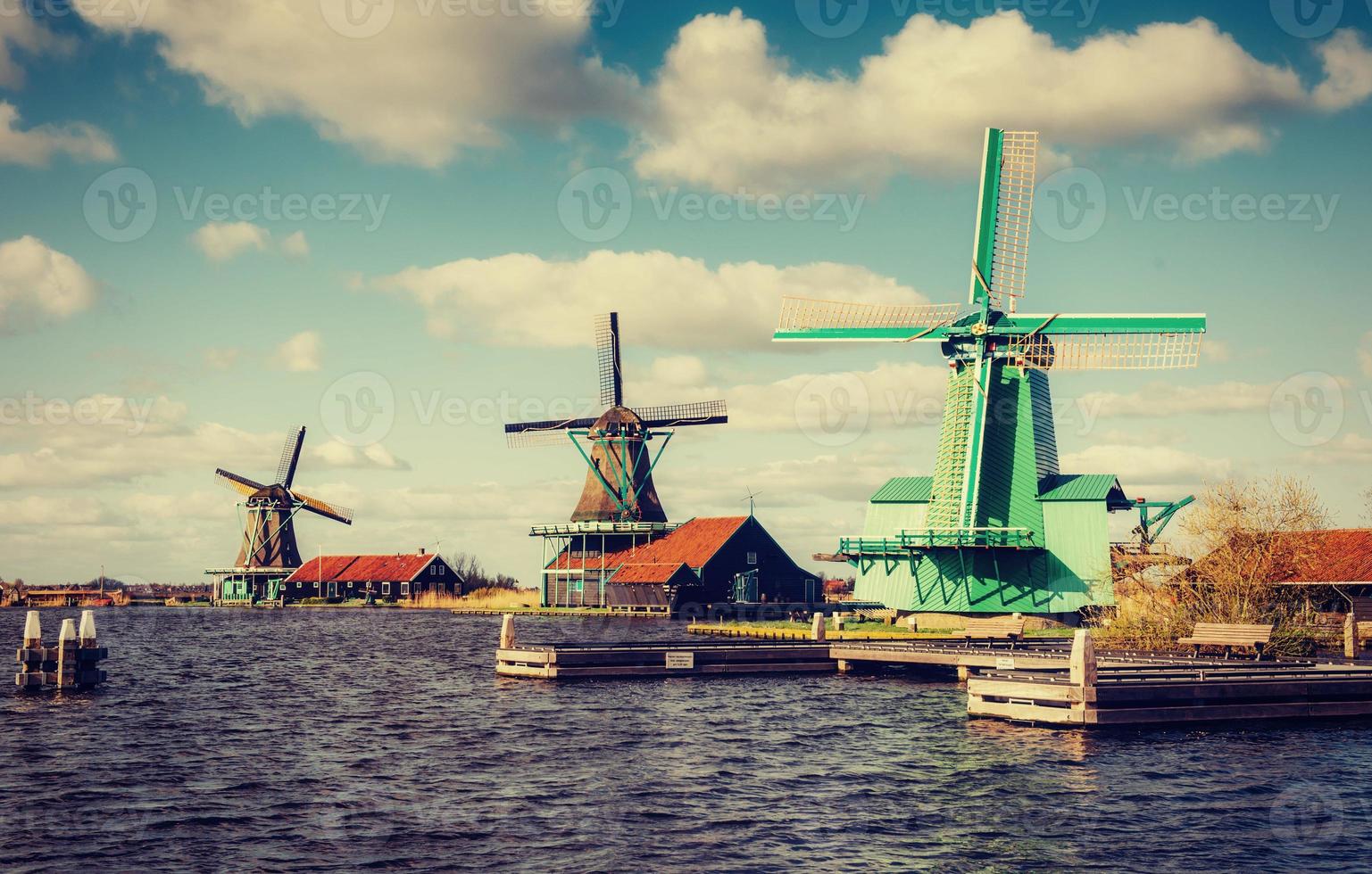 Colorful spring day with traditional Dutch windmills canal in Ro photo